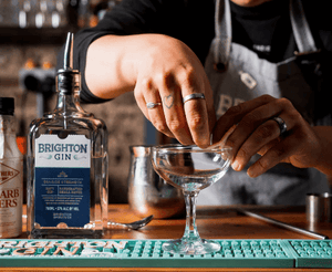 Brighton Gin with bartender hands shown over martini glass