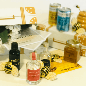 Flight of the Honeybee Gin Tasting Set showing bottles in front with honey and cans blurred